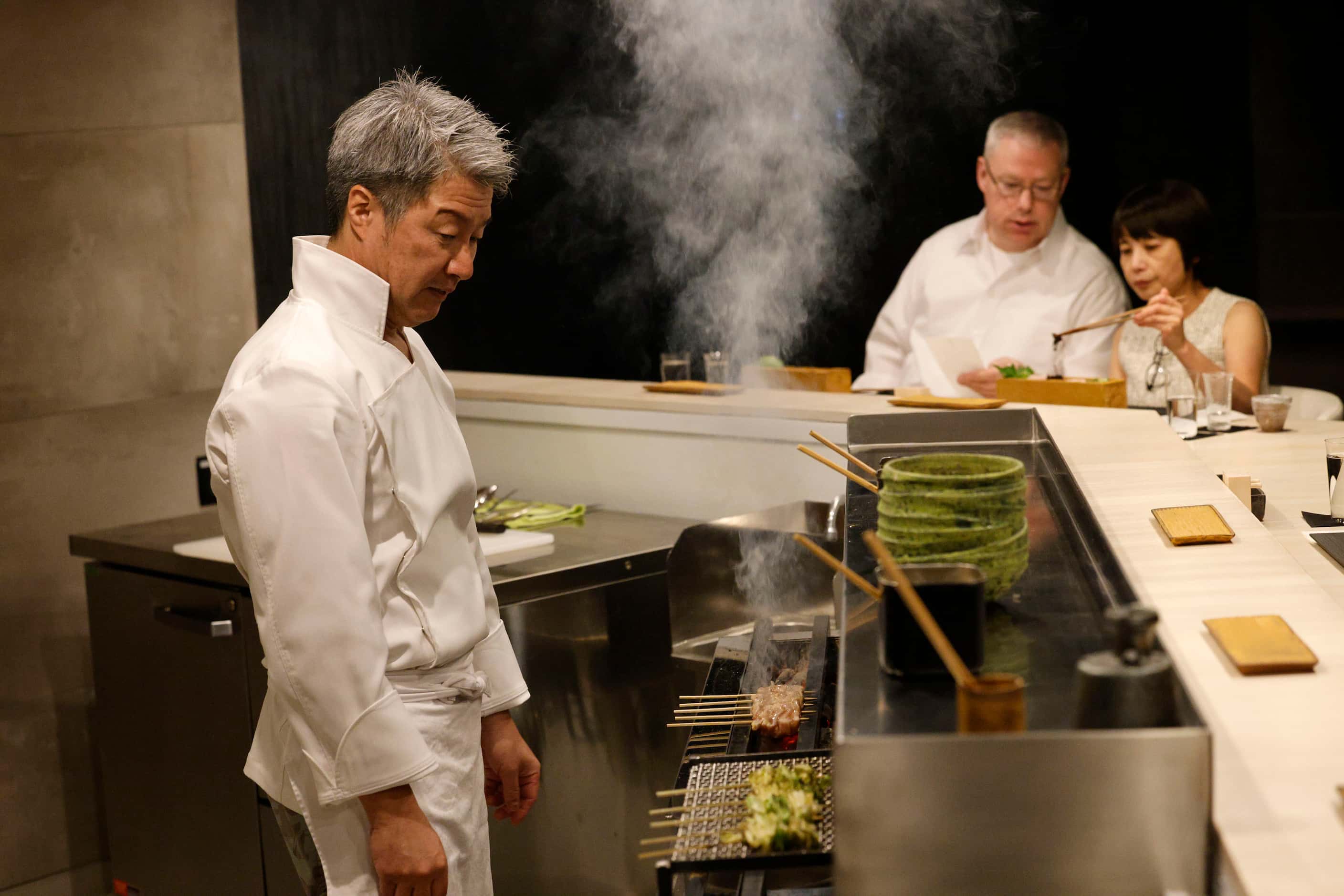 Chef Masayuki Otaka, left, prepares yakitori and kushiyaki at his new Japanese restaurant...