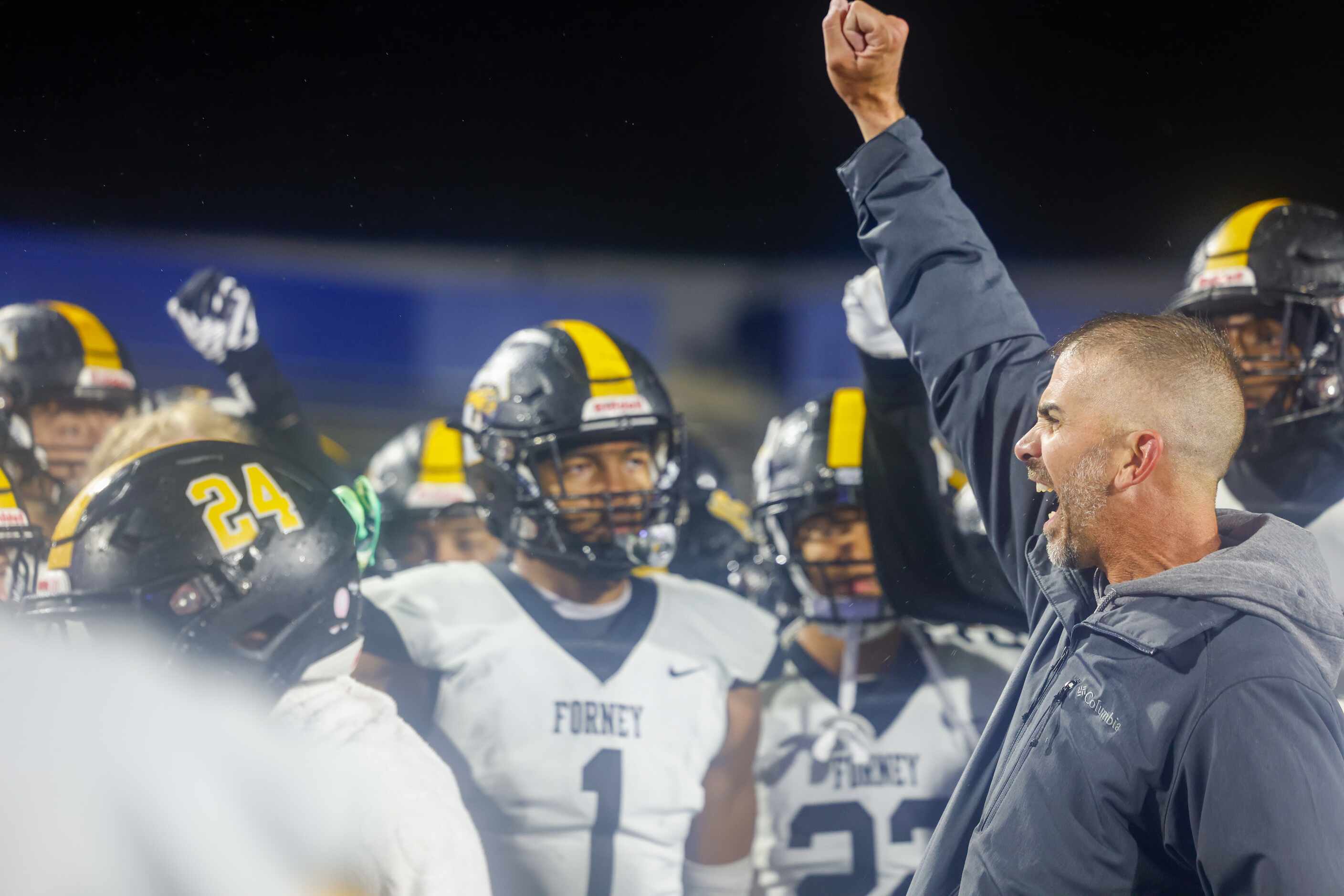Forney head coach Jeff Fleener (right) leads his players in a cheer after their win against...