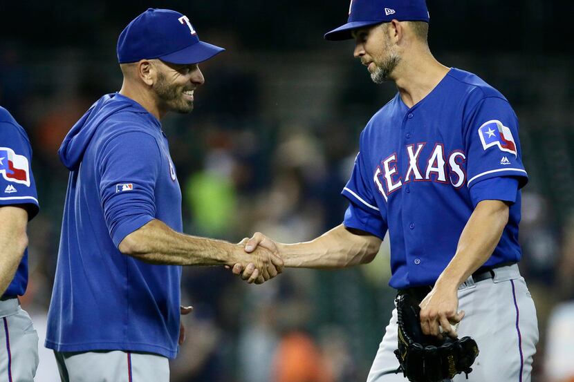 Manager Chris Woodward of the Texas Rangers congratulates starting pitcher Mike Minor,...