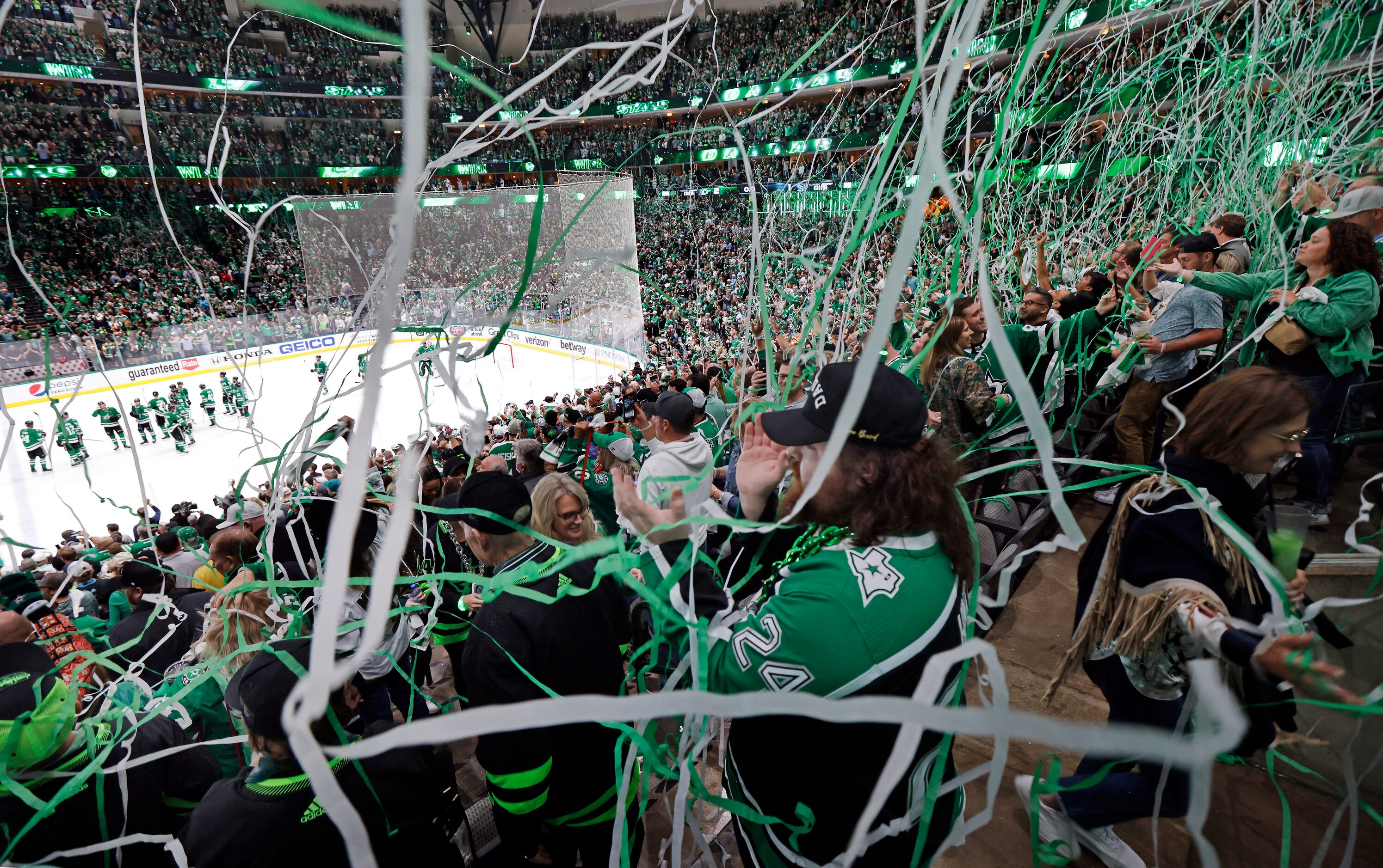 With paper streamers falling from the ceiling, Dallas Stars fans celebrate their series win...