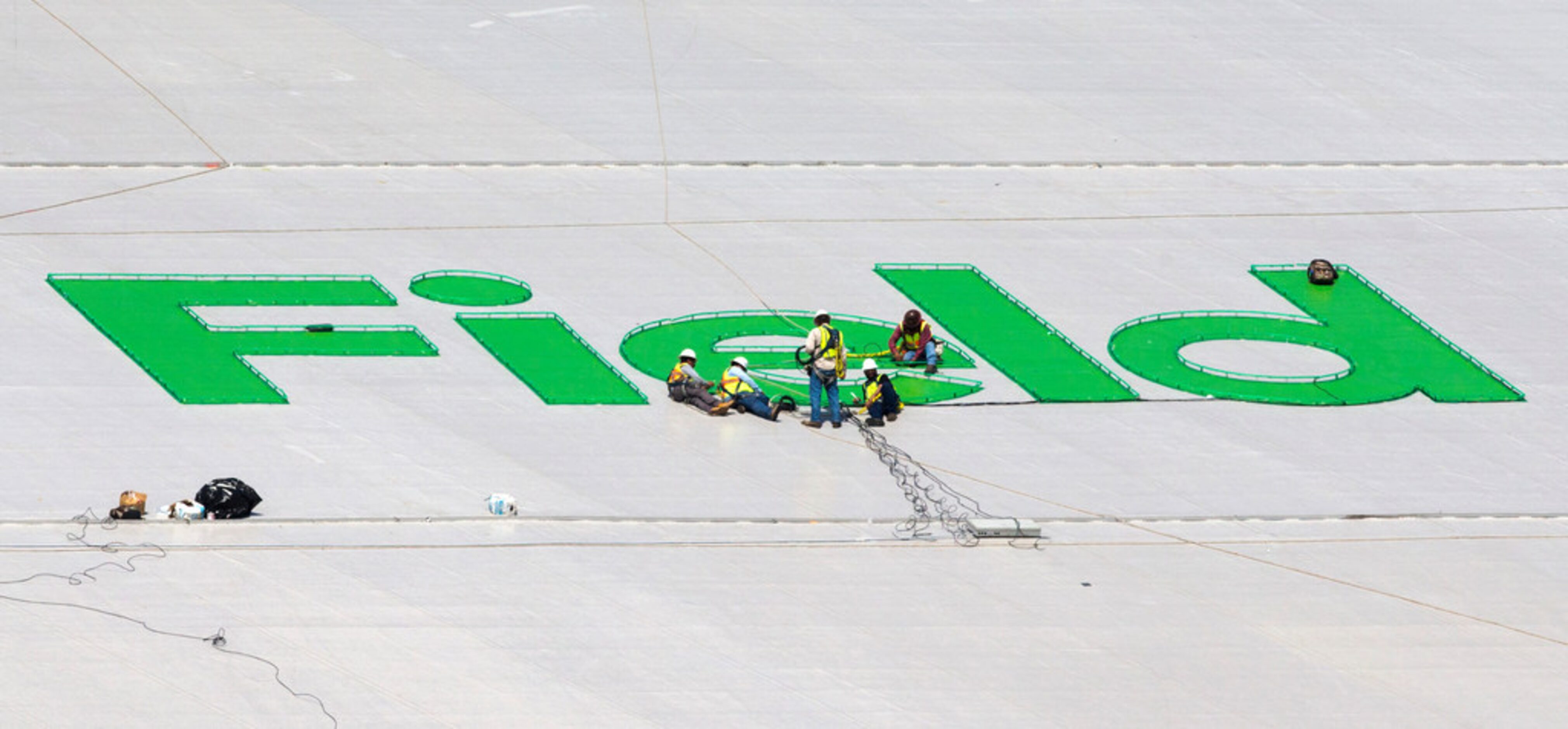 Crews work on a Globe Life Field logo on the roof of the stadium during an open house for...