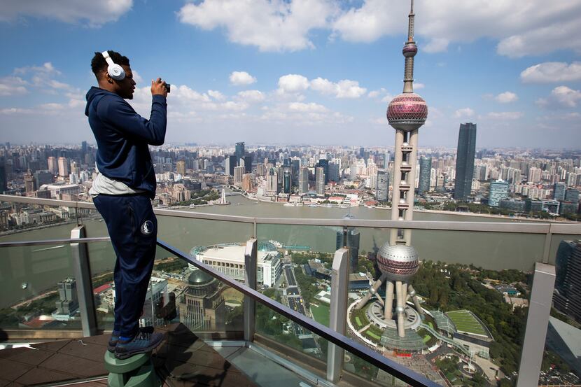 Dallas Mavericks guard Dennis Smith Jr. takes photos of the Oriental Pearl Tower and the...
