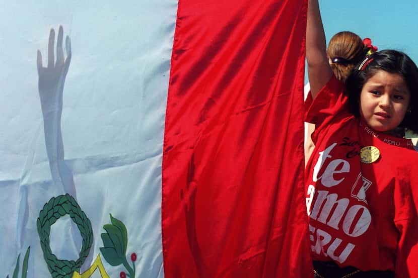 First-grader Natalie Gavalan holds the flag of Peru at Golden Meadows Elementary School in...