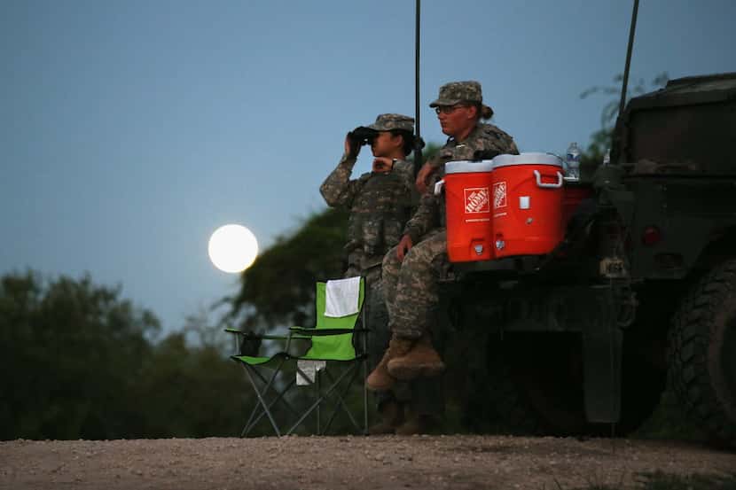  Texas National Guard troops watch for illegal immigrant crossings as a full moon rises near...