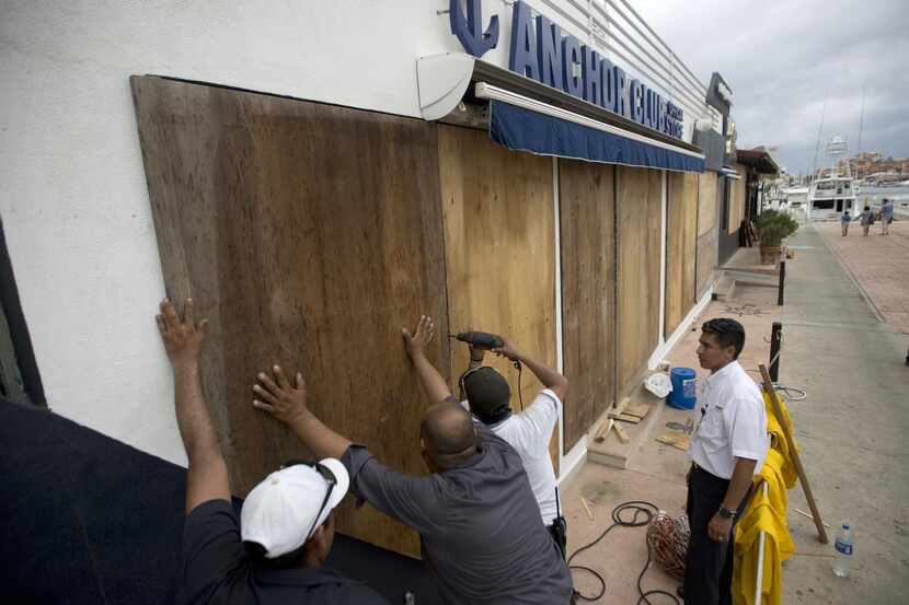 Trabajadores cubre las ventanas de un negocio en Cabo San Lucas, ante la llegada del huracán...