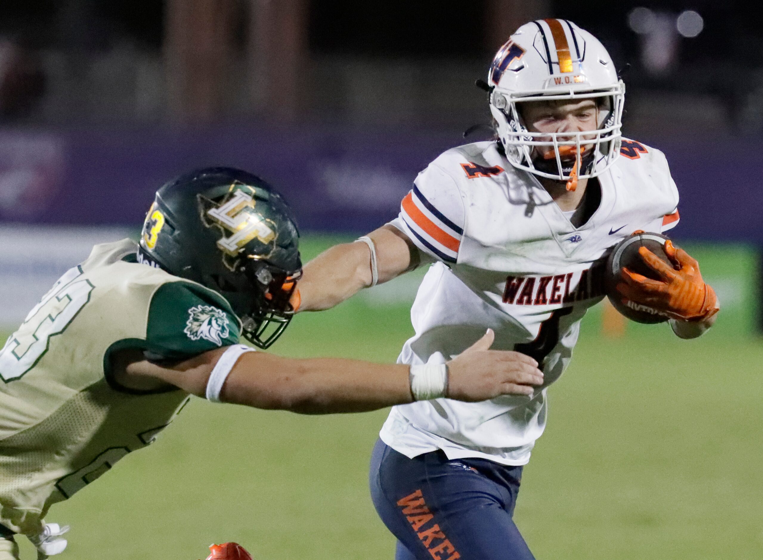 Wakealnd High School running back Cooper Snyder (4) puts a stiff arm on Lebanon Trail High...