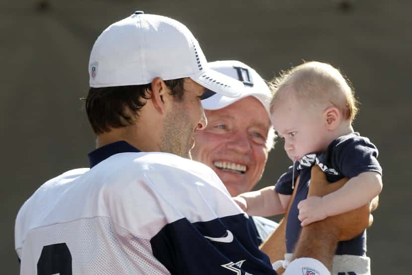 Dallas Cowboys quarterback Tony Romo (9) holds his son, Hawkins, with owner Jerry Jones,...