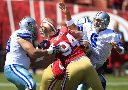 FILE - Dallas Cowboys quarterback Tony Romo (9) is hit as he throws by San Francisco 49ers...