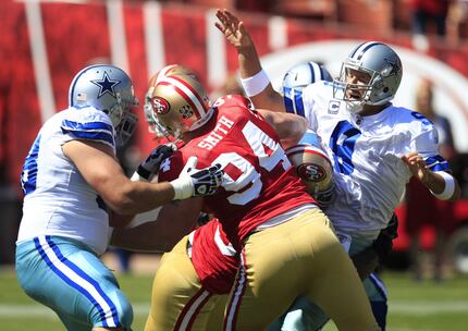 FILE - Dallas Cowboys quarterback Tony Romo (9) is hit as he throws by San Francisco 49ers...