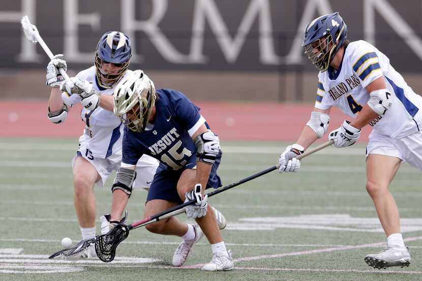 Dallas Jesuit's Sam Teachout (15) scoops up the ball between Highland Park's Mason Gallas,...