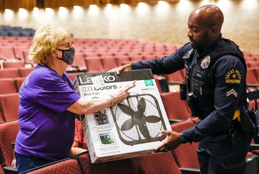 Dallas police Officer M. Spence gives an electric fan to Dallas resident Lila Martin at Lake...