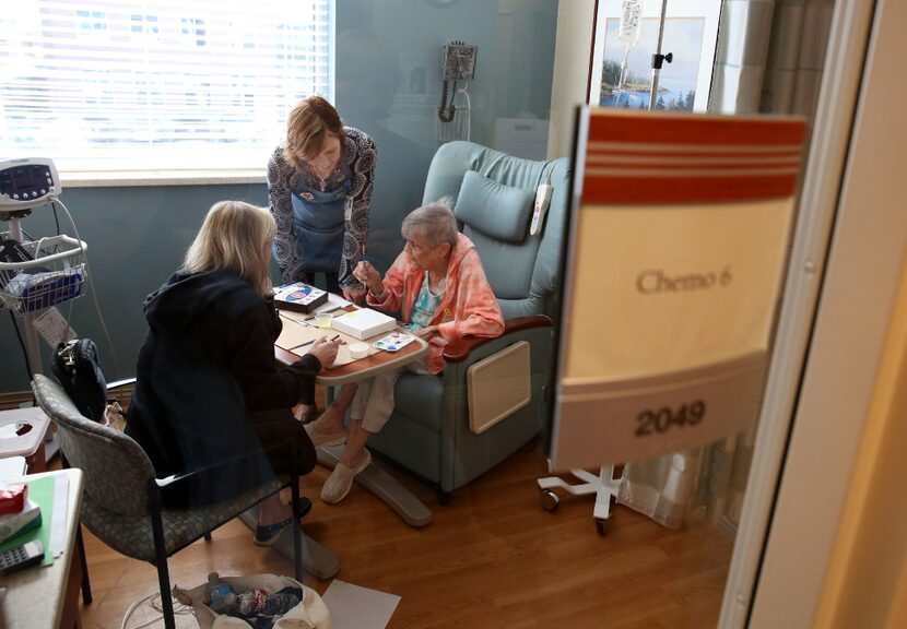 Katherine Baronet (middle), artist-in-residence at Methodist Richardson Cancer Center, helps...