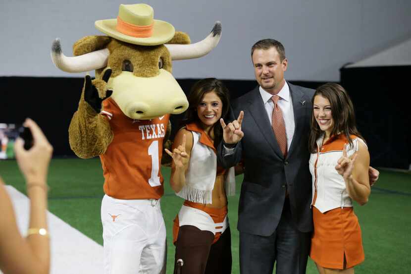 Texas head coach Tom Herman, second from right, poses for photos after speaking to reporters...