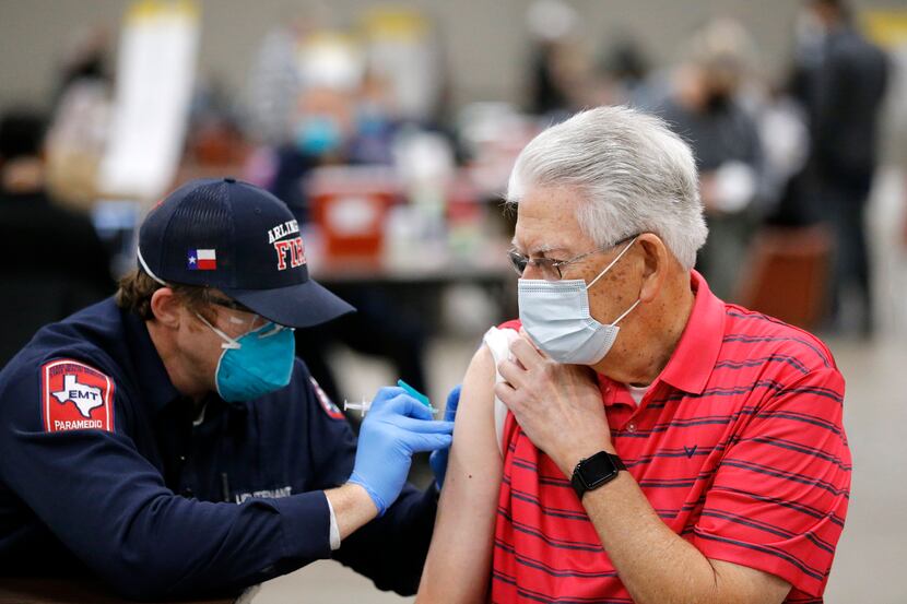 Jim Cox, 79, receives a COVID-19 vaccination from Arlington Fire Lt. Joshua Jones at Esports...