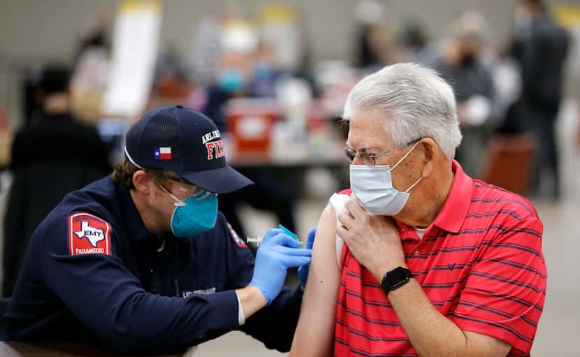 Jim Cox, 79, receives a COVID-19 vaccination from Arlington Fire Lt. Joshua Jones at Esports...