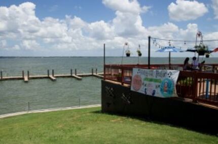  Patrons dine on the patio of Texas Land & Cattle Steak House as the boat dock is seen in...