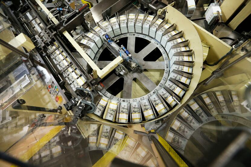 Stacks of $100 bills go through the production line in the COPE section at the Bureau of...