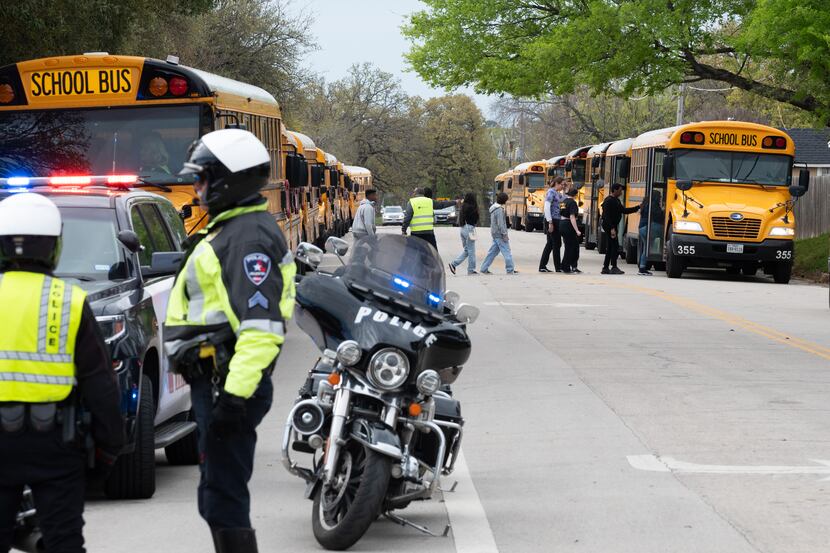 Arlington Police Officers black a street as Lamar High School students and faculty are...