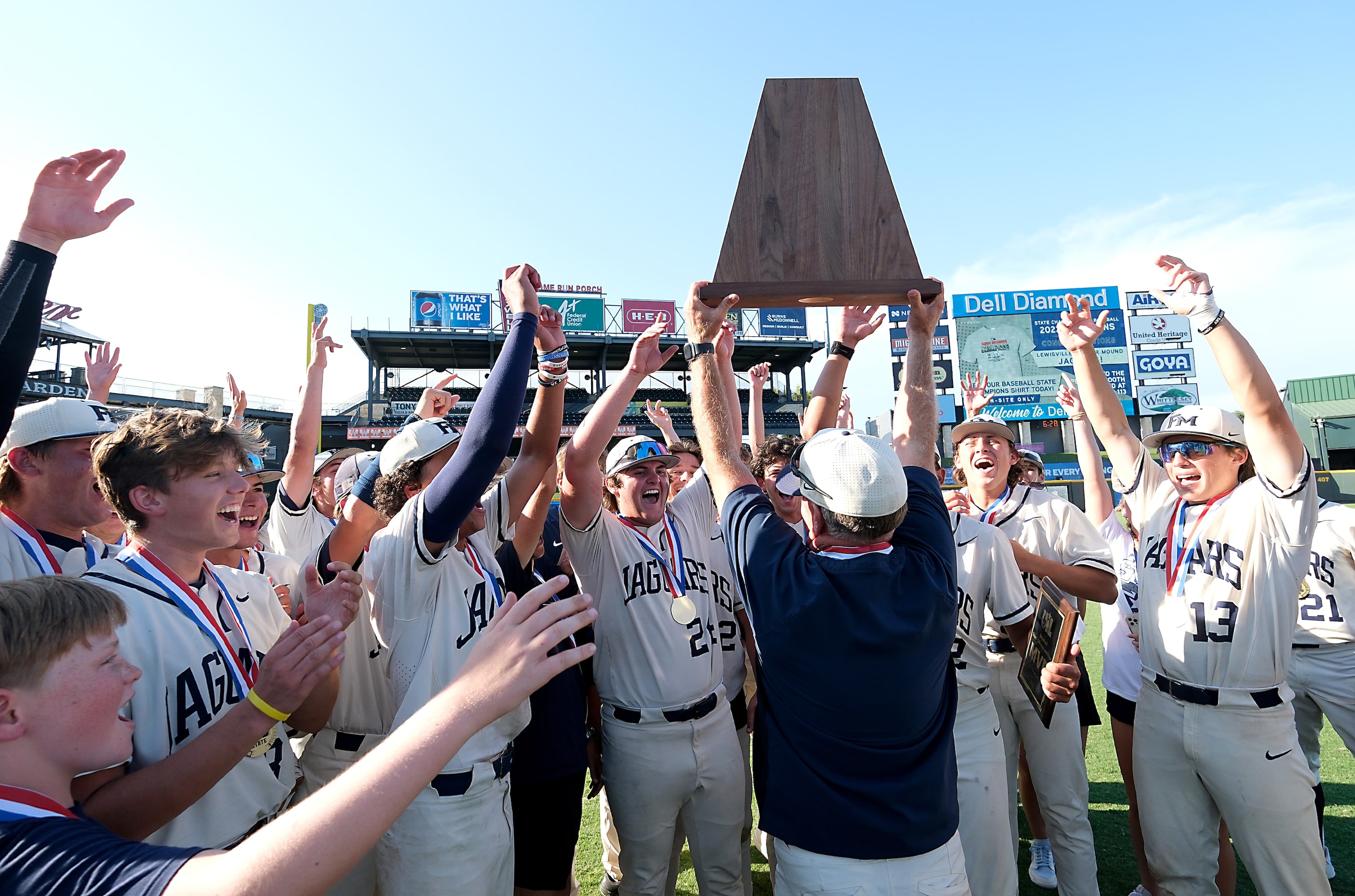 Flower Mound coach, Danny Wallace, lifts the championship trophy as he celebrates with the...