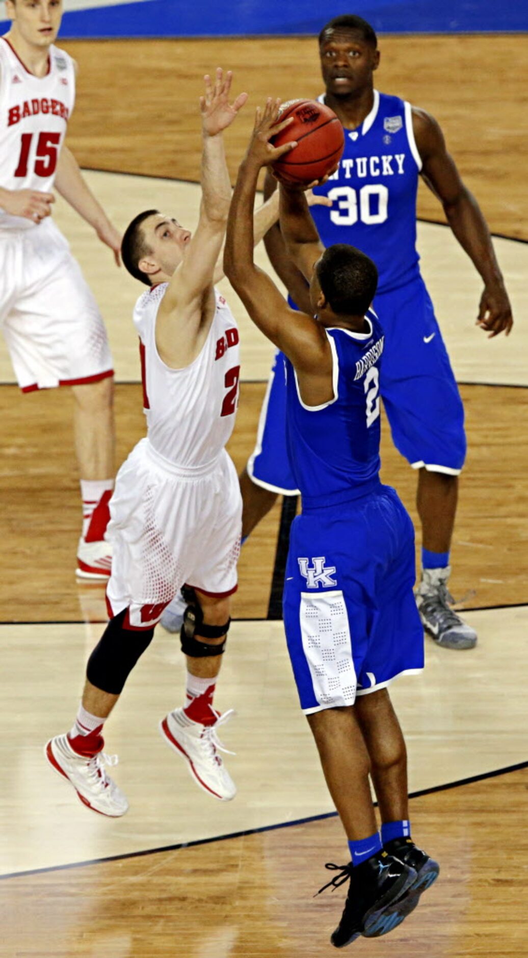 Kentucky Wildcats guard Aaron Harrison goes up against Wisconsin Badgers guard Josh Gasser...