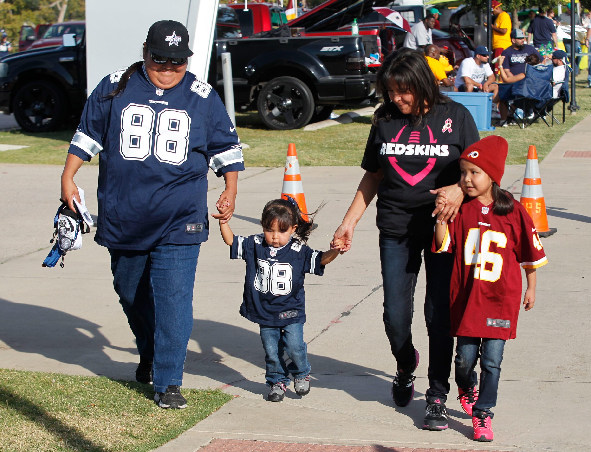 Cowboys fan Pamela Velasco, of Phoenix helps walk Teegan Martin, 2,  as Patricia Littlefish...