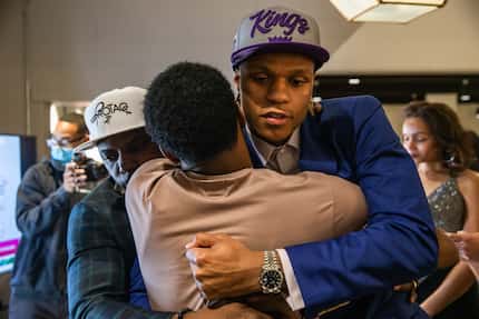 Jahmi'us Ramsey (center) receives an embrace from his father Avery (left) and brother...