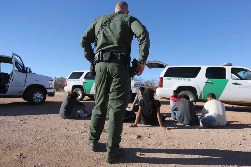 A Border Patrol agent detains suspected unauthorized immigrants in the area of Walker Canyon...