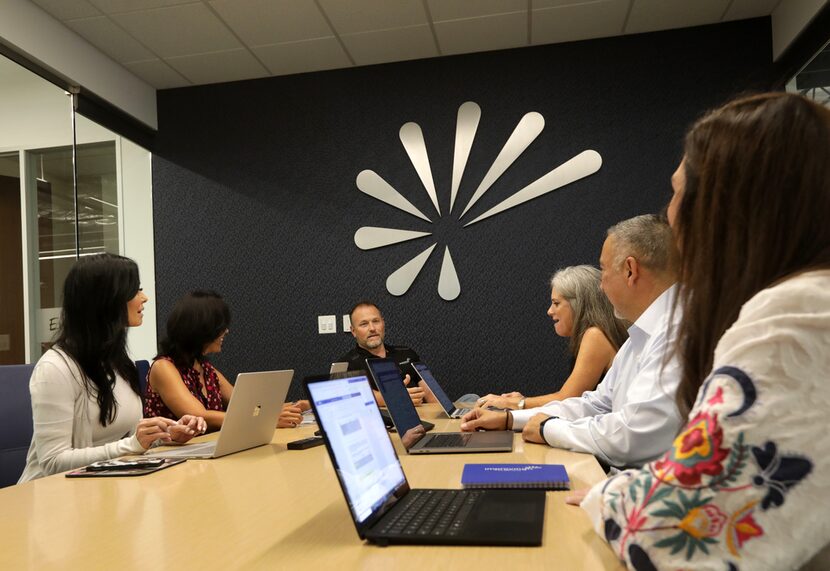 Curtis Hite, center, talks with part of the Improving team at its headquarters in Plano on...