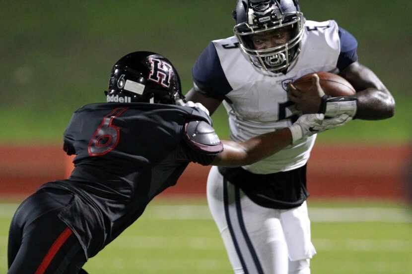 Wylie East QB Eno Benjamin (5) is stopped as he tries to get around Rockwall-Heath defender...