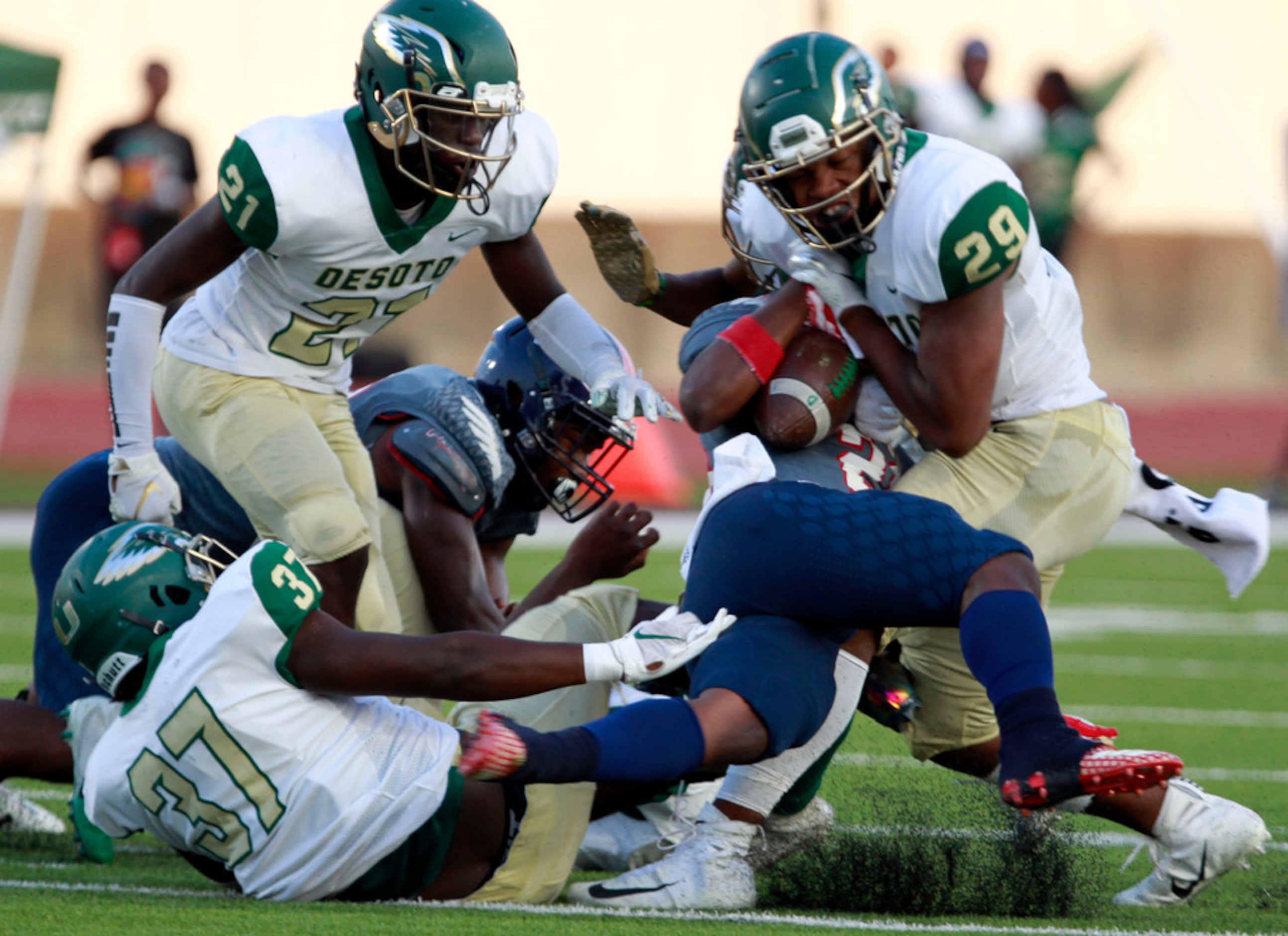 Bishop Dune RB Greg Lane (28) is twisted and tackled by several Desoto defenders, including...