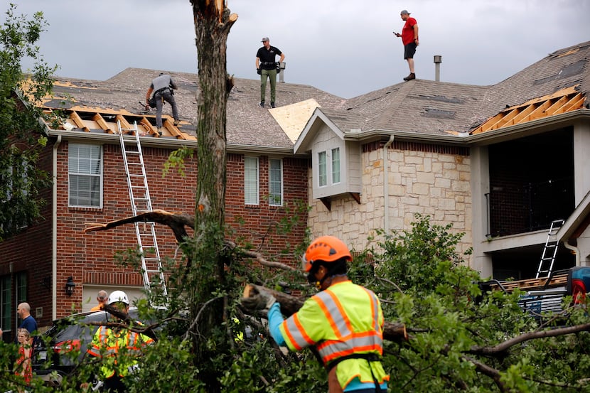 It was a hub of activity on Oliver Drive in North Fort Worth as crews cover damaged rooftops...
