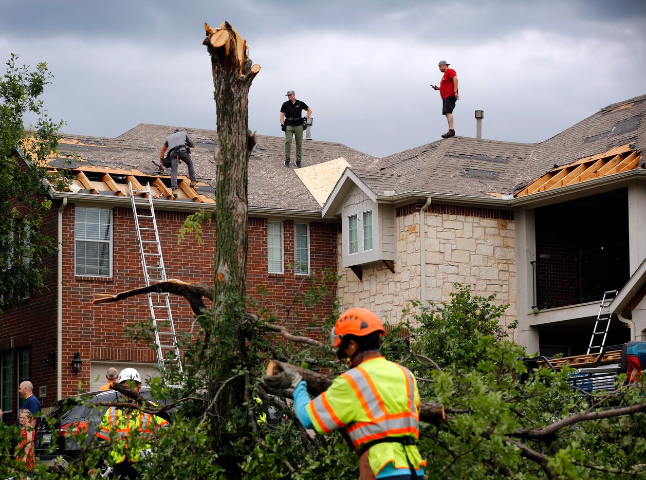 It was a hub of activity on Oliver Drive in North Fort Worth as crews cover damaged rooftops...