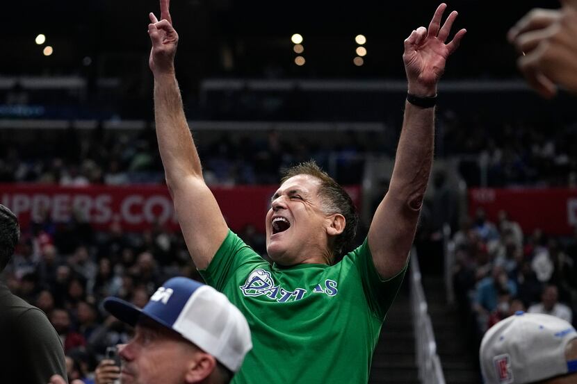 Dallas Mavericks owner Mark Cuban celebrates after guard Kyrie Irving scored during the...