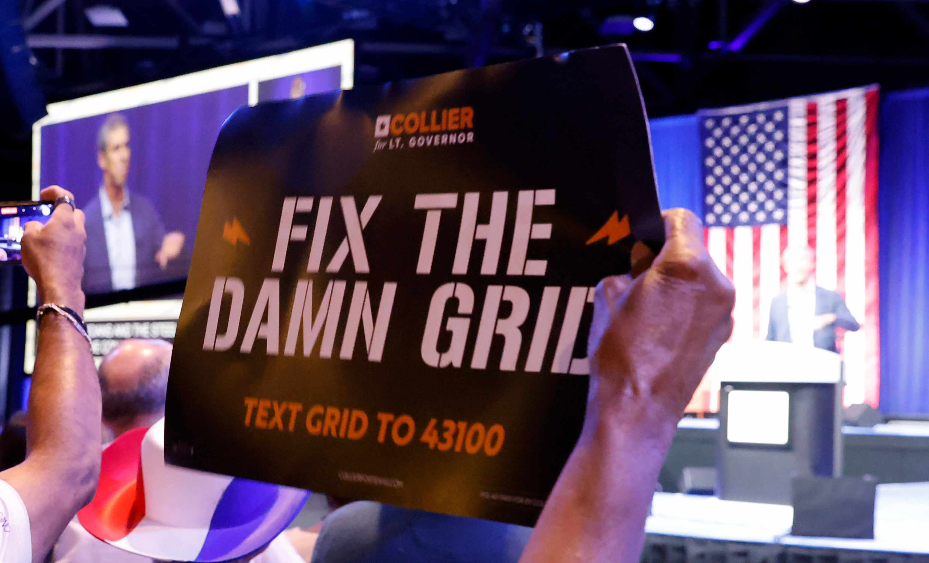 A delegate throws up a sign to Fix the Damn Grid as Democratic gubernatorial challenger Beto...