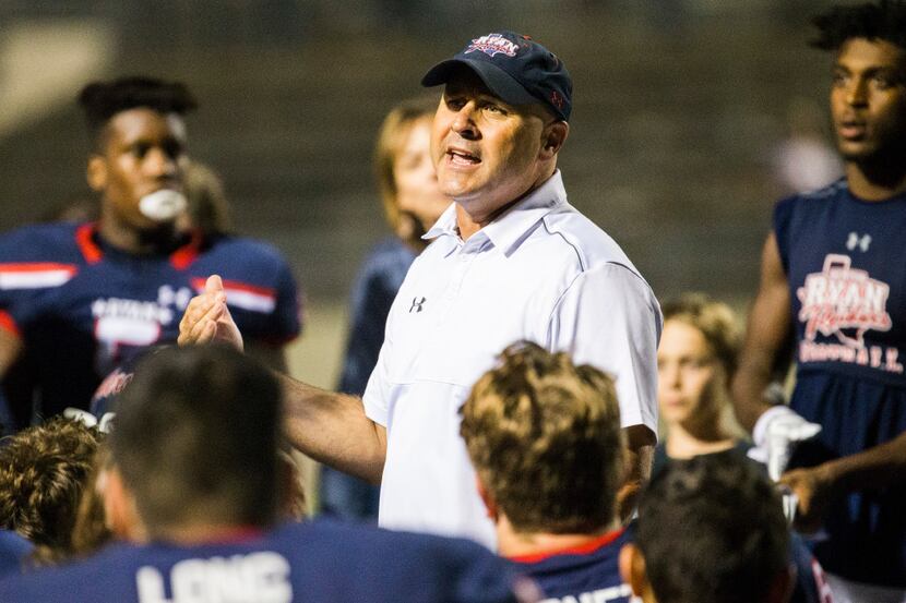 Denton Ryan head coach Dave Henigan talks to players after a 44-3 win in a high school...