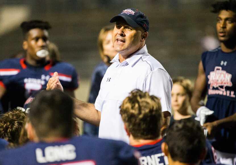 Denton Ryan head coach Dave Henigan talks to players after a 44-3 win in a high school...
