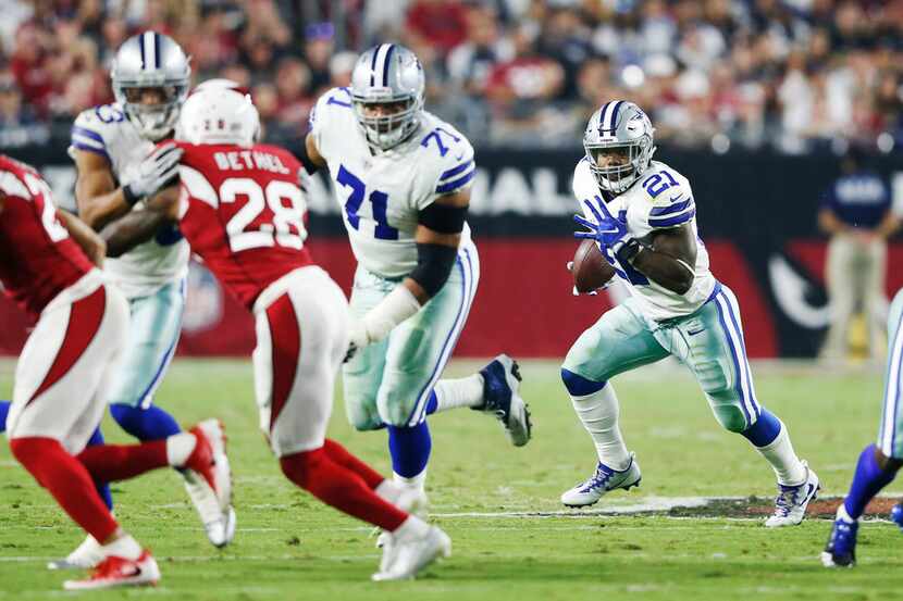 Dallas Cowboys running back Ezekiel Elliott (21) runs behind teammates Dallas Cowboys wide...