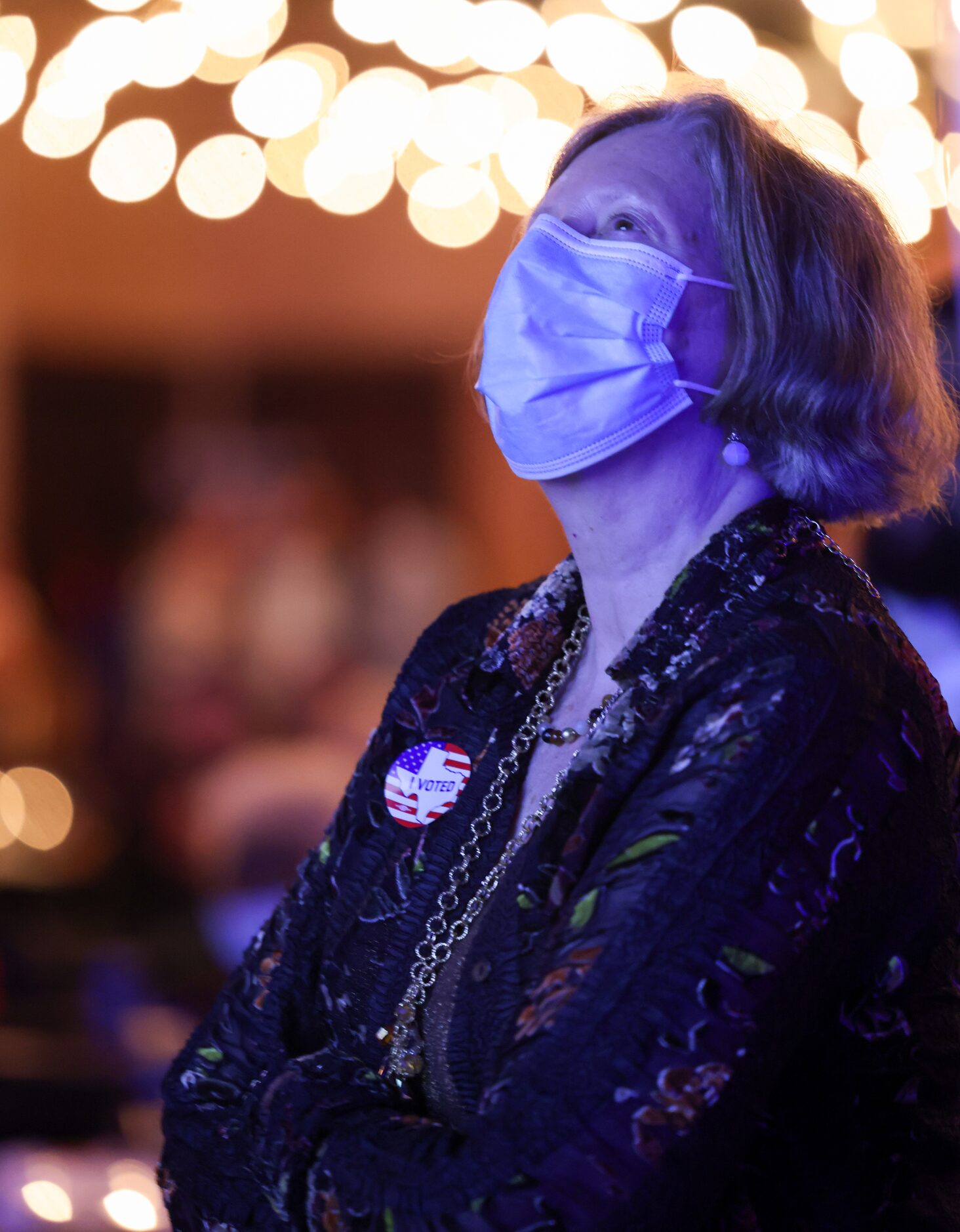 The blue from a large projector screen washes over Melody Nye as she watches results roll in...