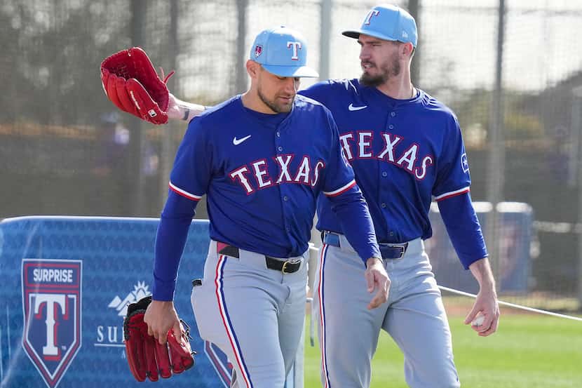 Texas Rangers pitcher Nathan Eovaldi (left) and pitcher Andrew Heaney walk between drills...