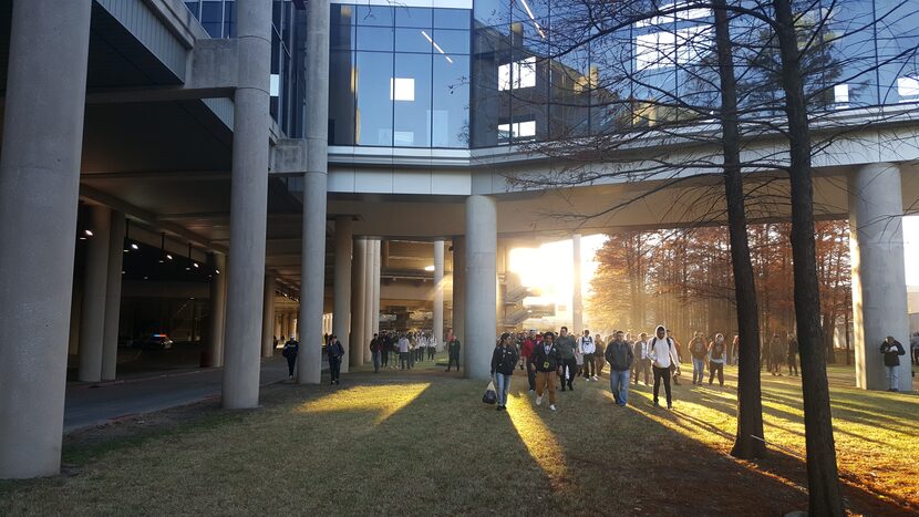 People file out of the Kay Bailey Hutchison Convention Center after being evacuated due to a...