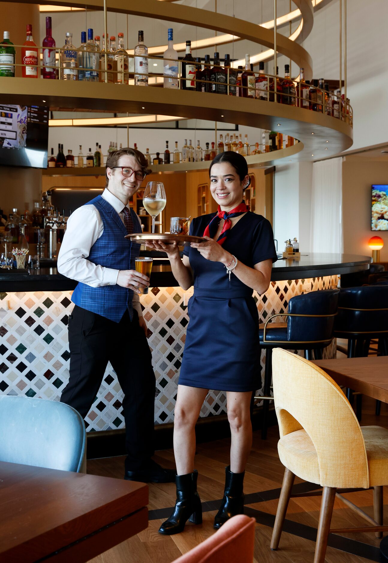 Bartenders Brady Smith and Bella Vasquez wear flight attendant-themed apparel in the...