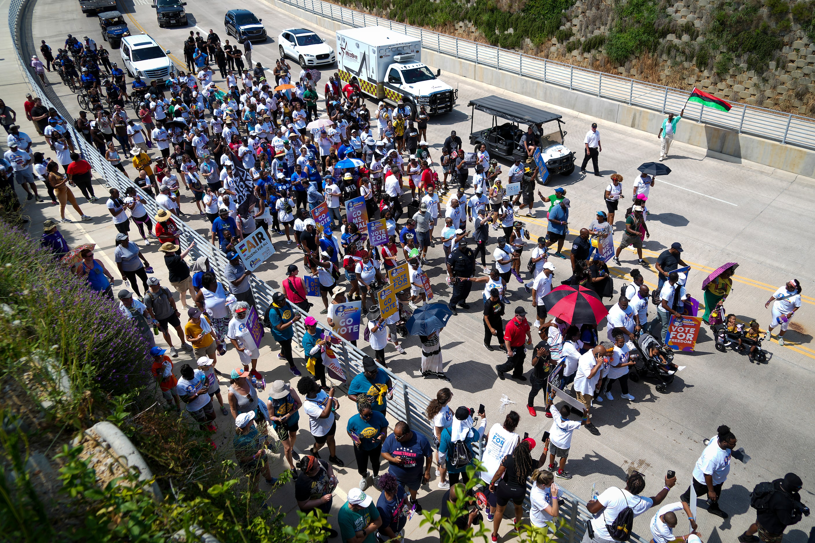 Opal Lee (center, bottom, wearing headband under red and black umbrella) leads hundreds of...