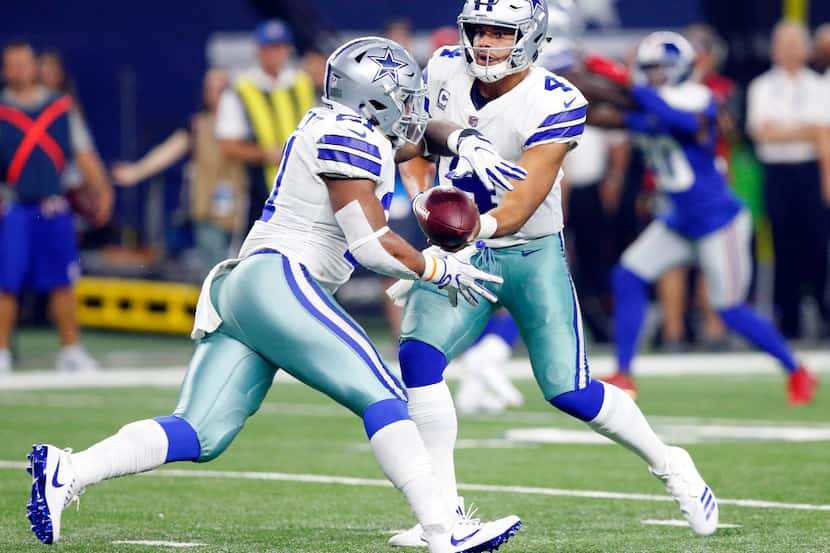 Dallas Cowboys quarterback Dak Prescott (4) hands the ball off to running back Ezekiel...