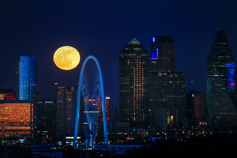 The full moon rises over the Dallas skyline in December 2018. 