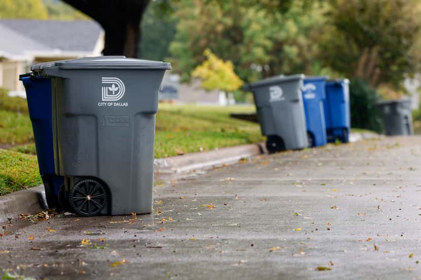 Recycling and garbage cans sit along a street in East Dallas, Friday, Oct. 28, 2022.
