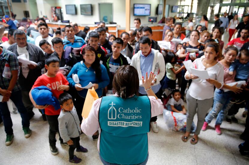 A staffer from the Catholic Charities of the Rio Grande Valley gives instructions to Central...