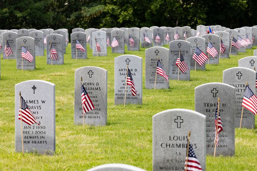 U.S. flags sit in front of headstones following a Memorial Day ceremony at Dallas-Fort Worth...