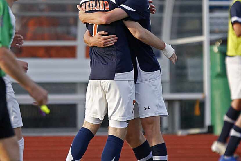 Wakeland High School's Corey Cantor (7) is embraced by team mate Brett Berdinsky (18) after...