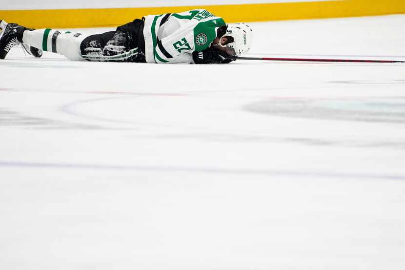 Dallas Stars left wing Mason Marchment holds his face on the ice after a collision during...
