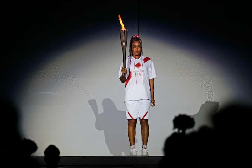 FILE - In this July 23, 2021 file photo, Japan's Naomi Osaka holds the Olympic torch during...